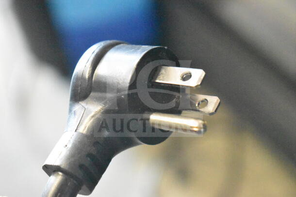 Close-up of a black three-prong plug, part of the True TVM-48SL-HC cooler.