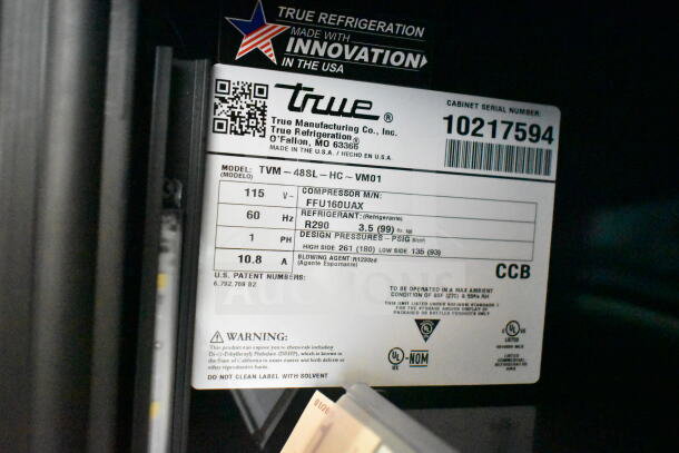 Label of 2021 True TVM-48SL-HC cooler showing model, voltage, and refrigerant details for auction.