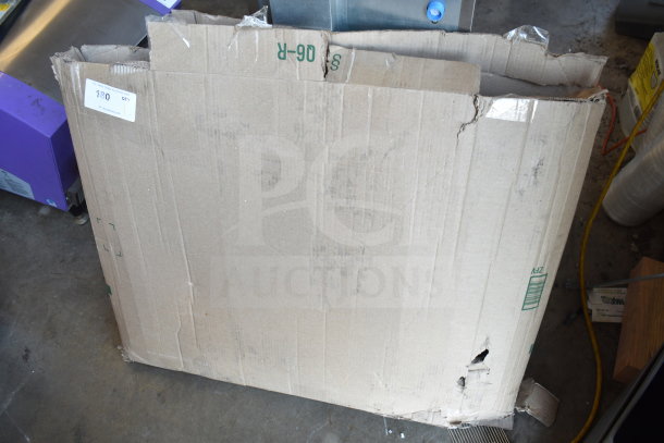 Damaged cardboard box labeled with price tag, possibly containing a beach chair. Box shows wear and tear.