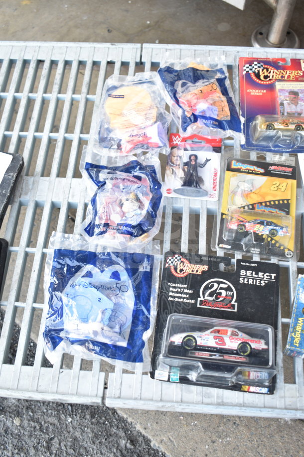 Assorted items including sealed die-cast cars, Disney-themed packages, and action figures. Various brands and conditions.