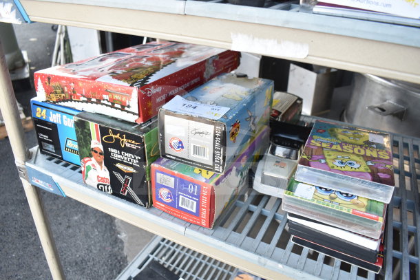 Assorted items with Texaco 1925 Stake Truck, Doodle Bug, DuPont 24 Stock Car, and a Mickey Mouse train set in boxes.