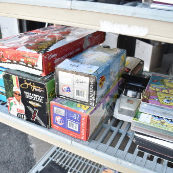 Assorted items with Texaco 1925 Stake Truck, Doodle Bug, DuPont 24 Stock Car, and a Mickey Mouse train set in boxes.