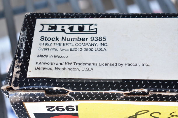 Box with ERTL Stock Number 9385, detailing Kenworth trademarks licensed by Paccar, Inc. Visible wear on the packaging.