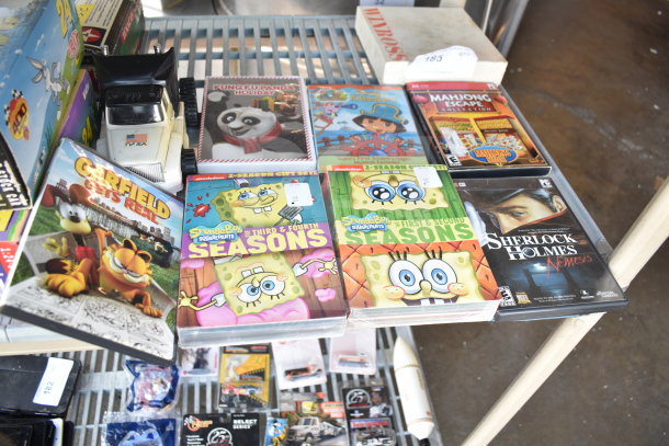 Various items include Texaco 1925 Stake Truck, DuPont 24 Stock Car, Mickey Mouse Train Set, DVDs like SpongeBob and Garfield.