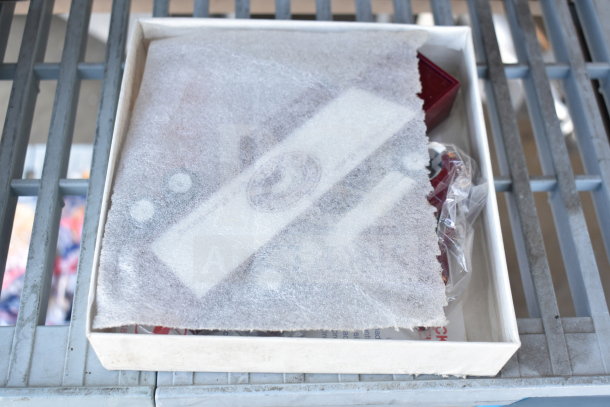 Winross Truck in open box, covered with protective paper. Red truck partially visible, packaging intact.