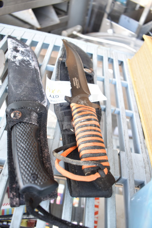 Assorted knives with sheaths, featuring detailed hilt and blade designs. Labels visible, offering unique auction value.