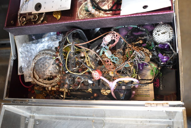 Case of assorted jewelry including necklaces and bracelets. Mixed materials, various styles, some packaged, in good condition.