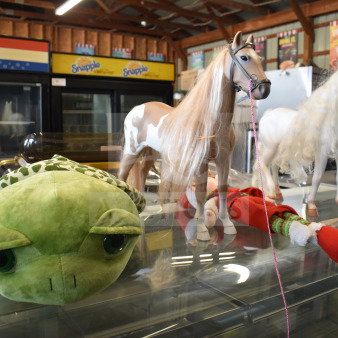 Lot of items includes a green turtle stuffed animal, two play horses with long manes, and a festive elf doll.