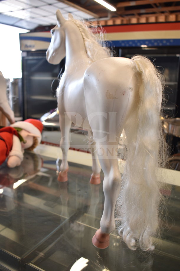 Lot of toys includes white plastic play horse with long mane, elf doll in Santa hat, and turtle stuffed animal. Horse shows wear.