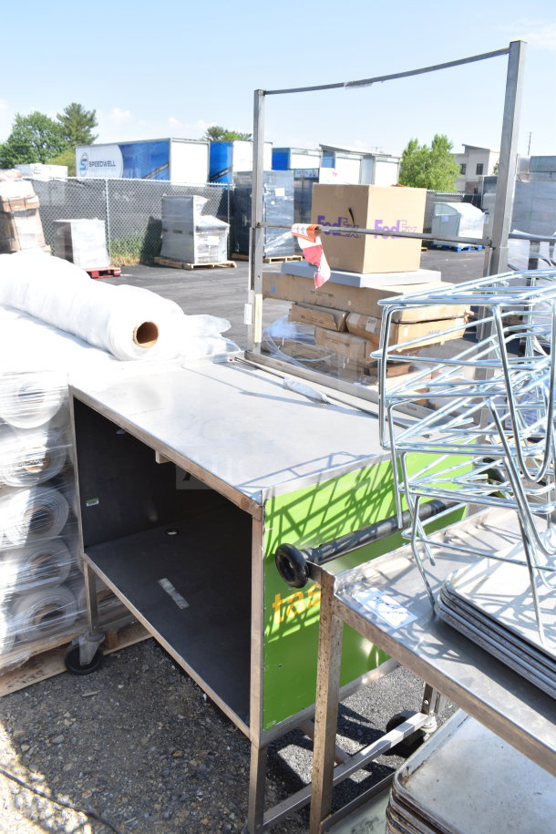 Commercial table with under shelf and commercial casters, outdoor setting, metal construction, good condition.