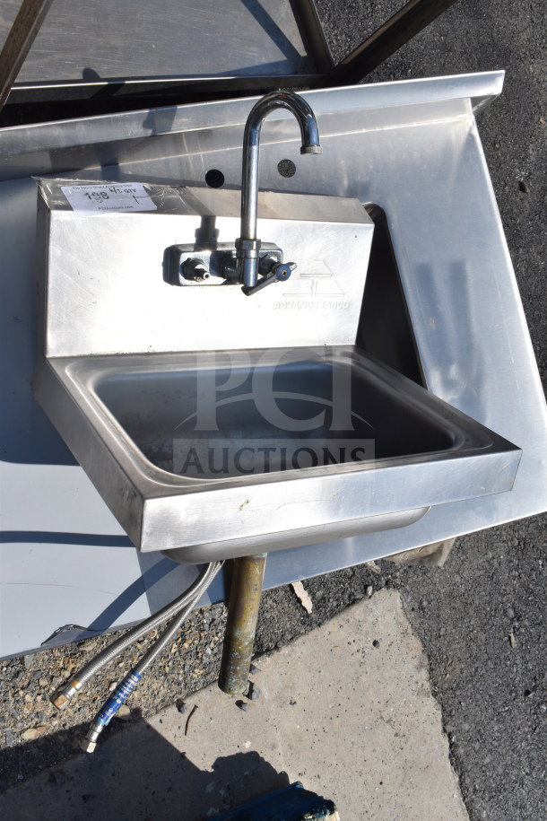 Commercial single bay wall mount sink with faucet and handles, stainless steel, used condition, brand markings visible.