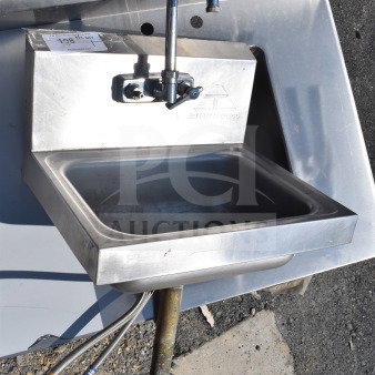 Commercial single bay wall mount sink with faucet and handles, stainless steel, used condition, brand markings visible.