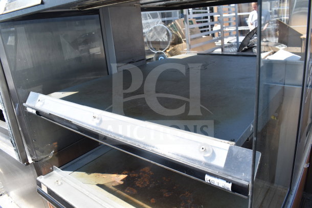 Custom Deli’s Inc commercial heated display case, 120/208 volts, 1 phase. Visible signs of wear, sturdy glass panes.