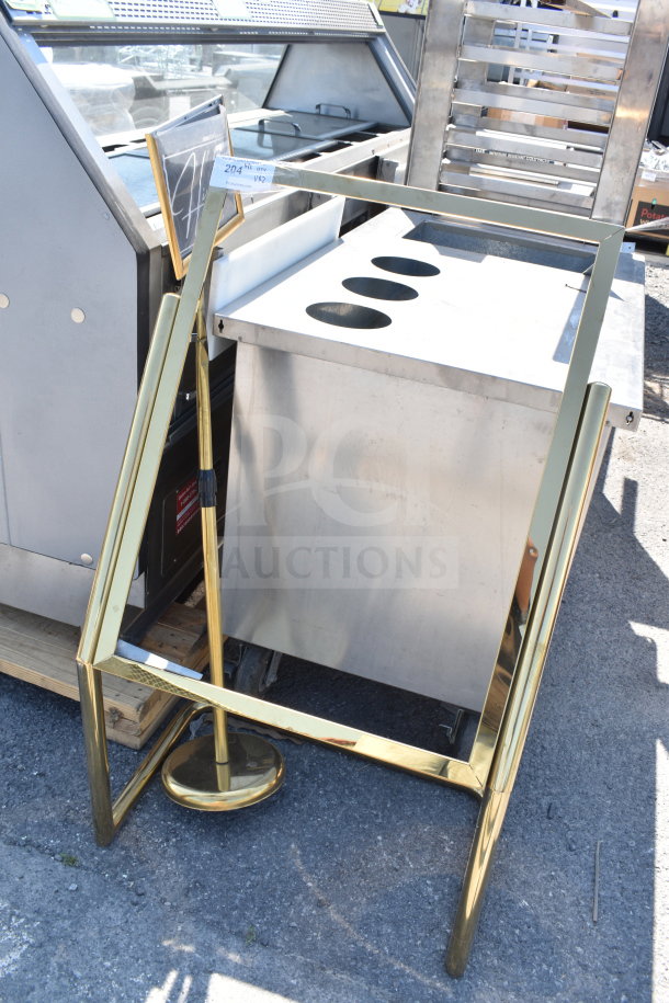 Gold sign frame with attached sign, featuring a sturdy base. Appears in good condition. Auction tag visible.