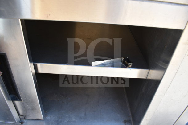 Delfield SC-50-NU serving counter with enclosed base, stainless steel, shows interior shelf and metal utensil.