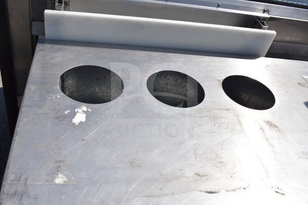 Delfield SC-50-NU 50" serving counter with solid top, three recessed areas, and enclosed base; shows wear, commercial use.