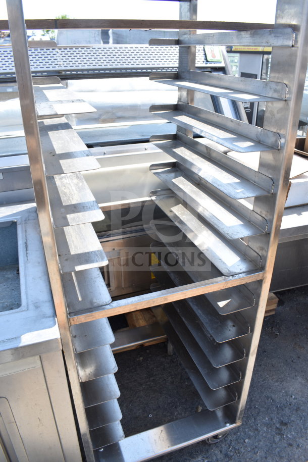 Commercial pan transport rack with metal shelves and commercial casters, in good condition, outdoor setting.