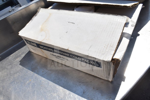 Cardboard box labeled "Uline Moisture Resistant Cold Packs," slightly worn, on a metal surface.