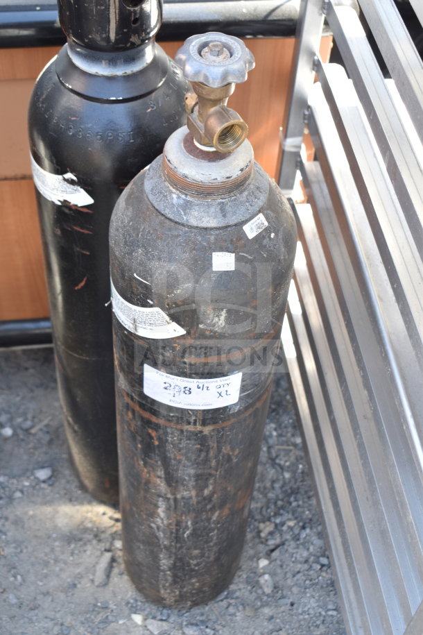 Two large nitrogen tanks, black with valves, labeled "298 1/2 27Y XL." Tarnished surface, pickup only, no shipping.