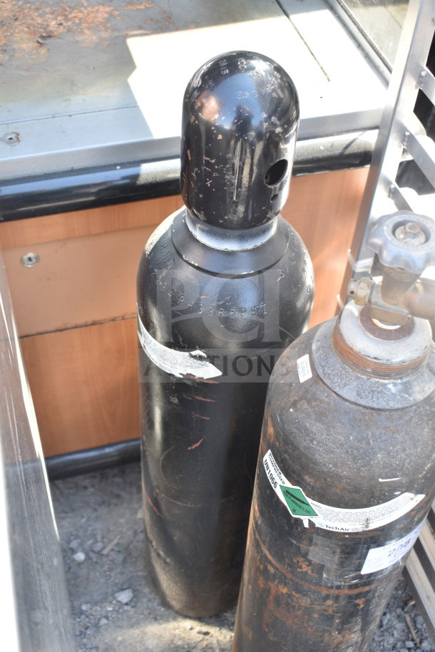 Two large nitrogen tanks with visible wear and labeling. Buyer pick-up required; no shipping available.