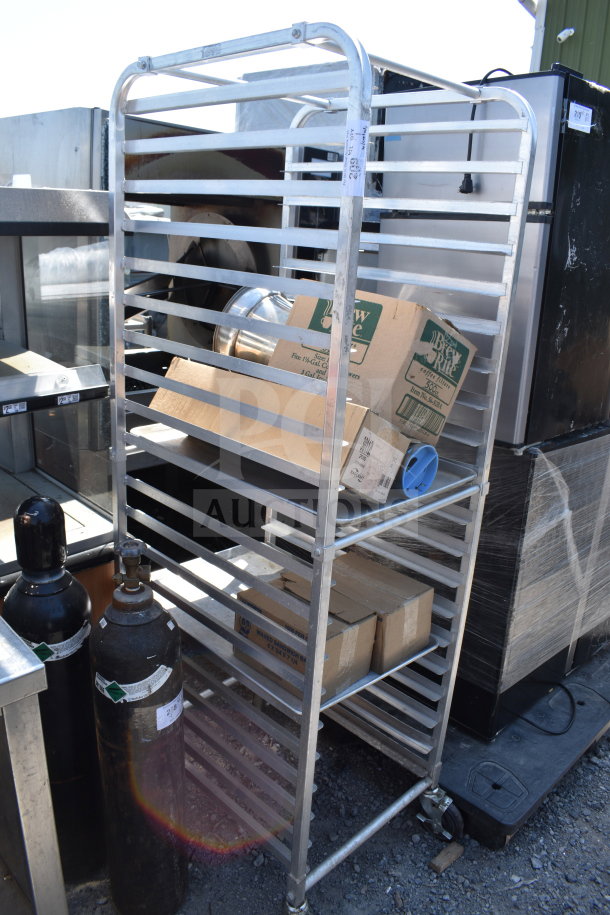 Commercial pan transport rack with multiple shelves, mounted on sturdy commercial casters, in used condition.