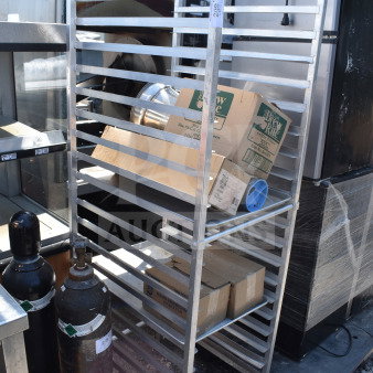 Commercial pan transport rack with multiple shelves, mounted on sturdy commercial casters, in used condition.