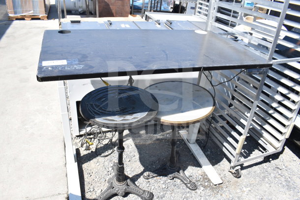 Three tables for auction: one rectangular, two round with ornate bases. Condition shows wear. Includes three times bid multiplier.