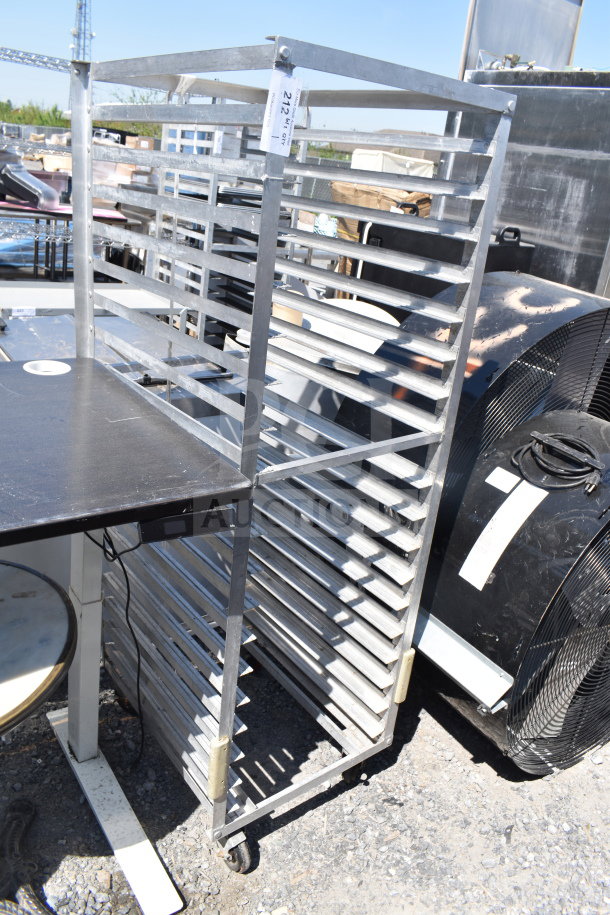 Commercial pan transport rack with metal shelves and commercial casters, shown outdoors. Good condition, tag labeled "212".