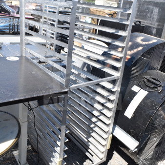 Commercial pan transport rack with metal shelves and commercial casters, shown outdoors. Good condition, tag labeled "212".