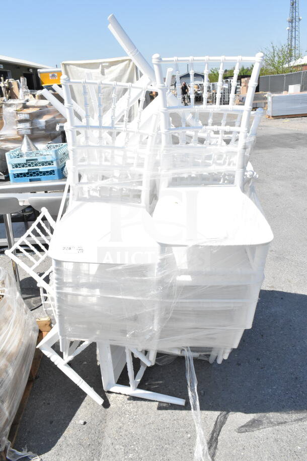 White wood Chiavari chairs by Lancaster Table & Seating, scratch and dent, wrapped in plastic, stacked on palette.