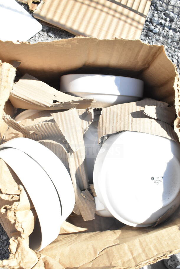 Three stackable white bowls, including a 303SCD16WH, with raised rims in a torn cardboard box. Marking reads "Libbey Porcelain."