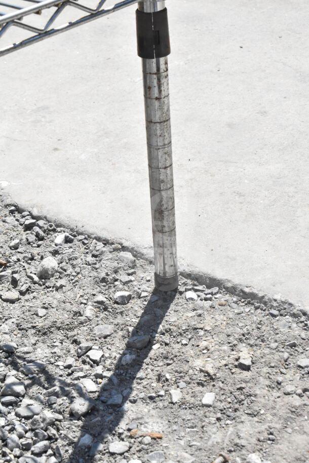 Chrome finish 3-tier wire shelving unit leg on concrete. Buyer must dismantle.
