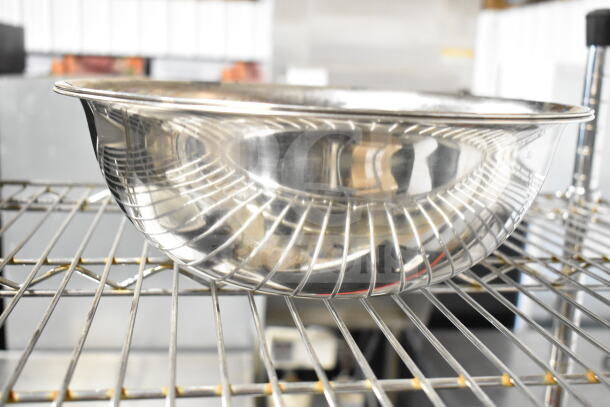 Metal bowl with a reflective finish on a wire rack. Part of a set including various items. Appears in good condition.