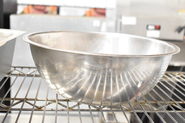 Metal bowl on a shelf, shiny exterior, part of auction lot with three items including bowls and a drop-in bin.