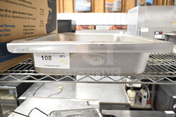 Metal drop-in bin with inventory label, number 108, marked "QTY X3." Item on metal shelving in industrial setting.