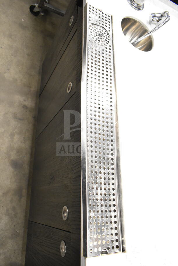 Sleek portable bar with stainless steel sink and perforated drip tray, dark wood cabinet doors, and modern fixtures.