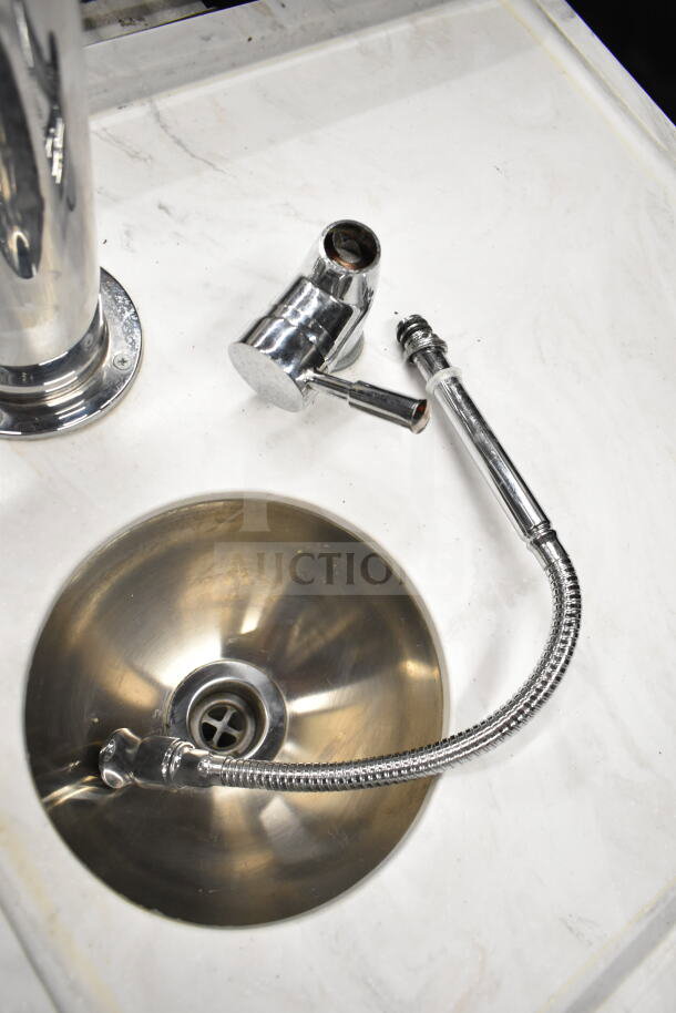 Stainless steel bar sink with flexible faucet on a white counter, part of a portable bar setup.