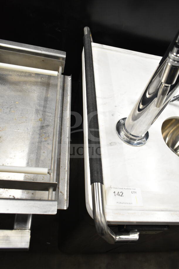 Portable bar with metal frame, white countertop, and chrome fixtures. Visible label reads "#142, PCI Auctions." Good condition.