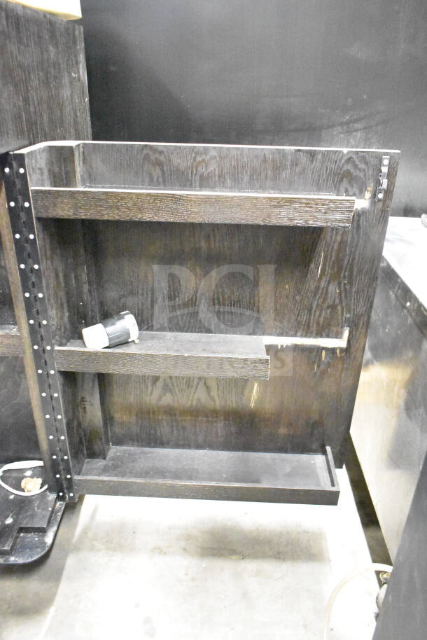 Dark wood portable bar with shelves, minor scratches, and a metal detailing strip along the side. Suitable for compact spaces.