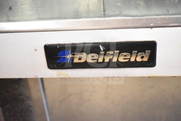 Delfield deli display case merchandiser with logo, stainless steel, commercial use. Slight wear visible.