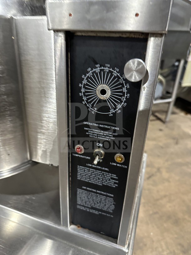 Commercial stainless steel electric tilting steam-jacketed kettle on legs, temperature gauge, and operation instructions.
