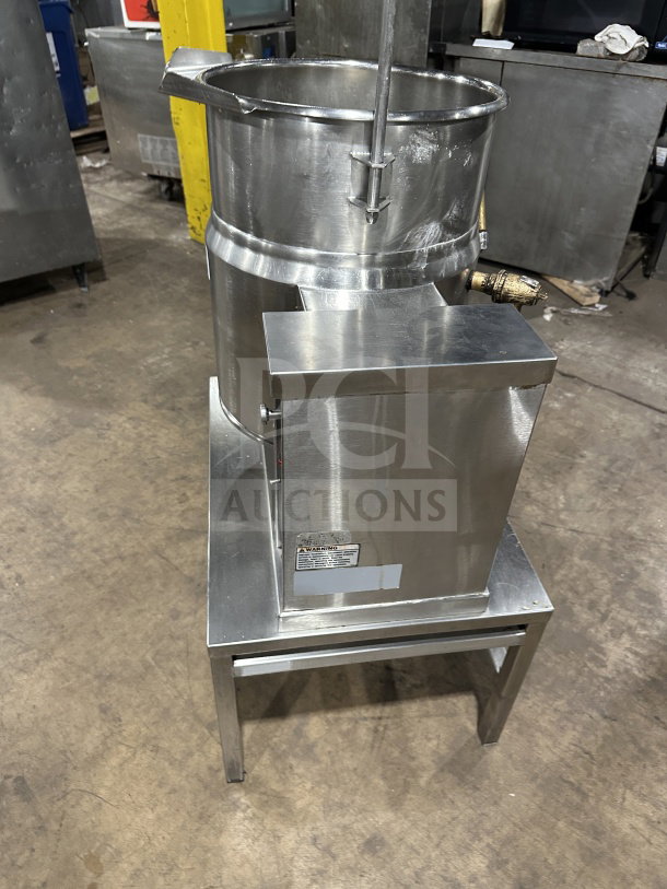 Commercial stainless steel electric tilting steam-jacketed kettle on legs, excellent condition, with visible warning label.