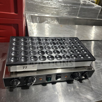 Stainless steel and cast iron mini Dutch pancake maker with 50 round molds. Features temperature knobs and power switch.