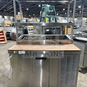 Delfield stainless steel pizza prep table with refrigerated base, double overhead shelf, and chrome rack. Model fits 115V 1 Phase.