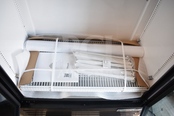 Brand new True TVM-36SL-HC commercial cooler components, neatly packaged with labels and documents, inside the unit.