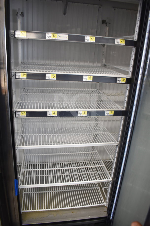 2018 True GDM-72F-HC 3-door commercial freezer with multiple shelves, visible price labels, clean interior, and glass doors.