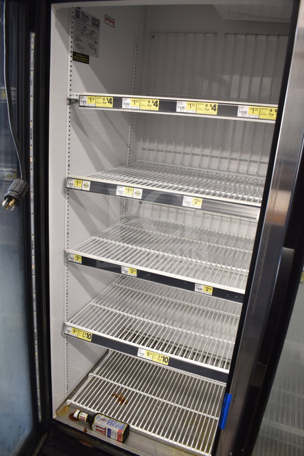 2018 True GDM-72F-HC Commercial Freezer. Three glass doors, wire shelves, visible price tags, clean interior.