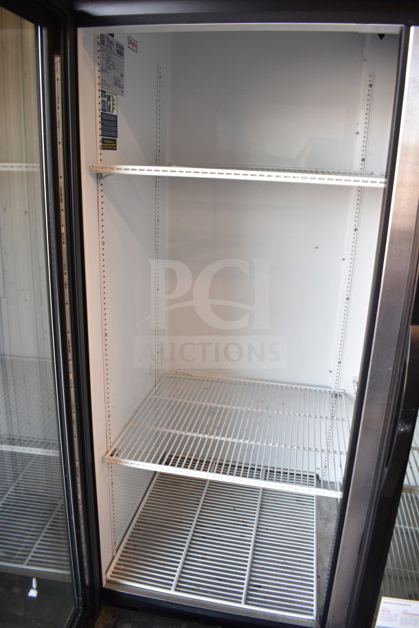 2019 True GDM-72-HC 3-door reach-in cooler merchandiser, clean interior, metal shelving, model and voltage label visible.