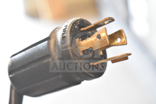 Close-up of a power plug from a 2018 True GDM-72F-HC commercial freezer, showing prongs and labels.
