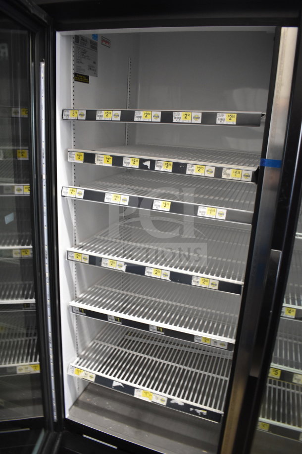 2018 True GDM-72-HC commercial 3-door reach-in cooler merchandiser, empty, with shelving and product labels visible.